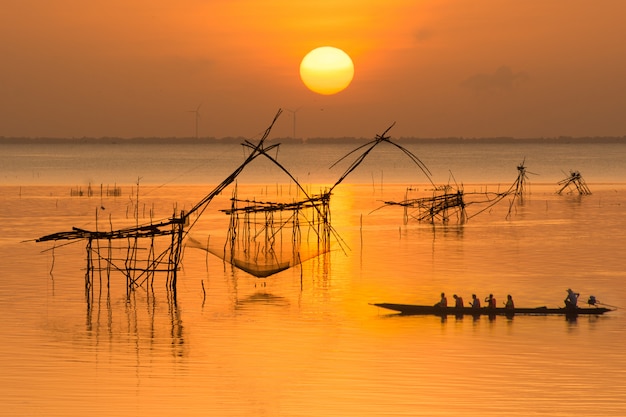 Céu do nascer do sol com pescador no barco