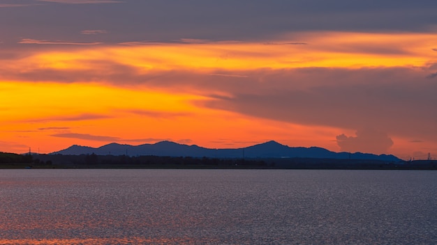 Céu do por do sol e sol grande sobre o lago.