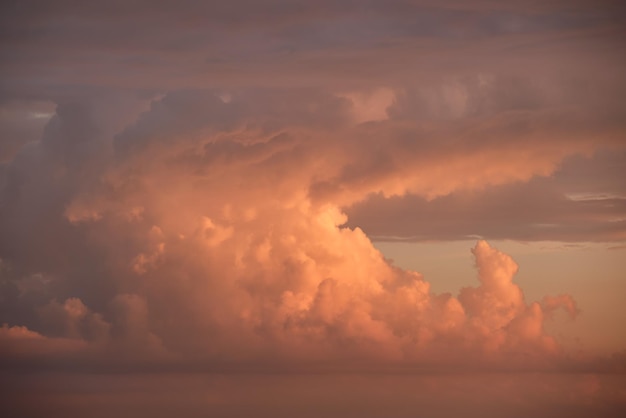 Céu do sol colorido brilhante com nuvens suaves vívidas iluminadas com luz do sol se espalhando para o horizonte