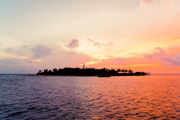 céu do sol com ilha Maldivas