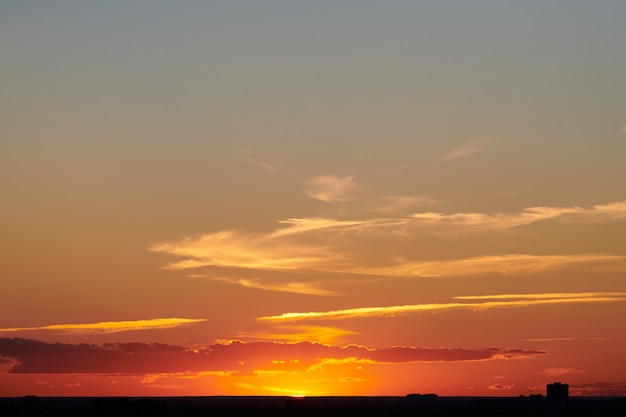 Céu do sol da cidade. Bela noite cênica ao longo do horizonte da cidade. Pôr do sol colorido. Céu limpo e calmo ao anoitecer