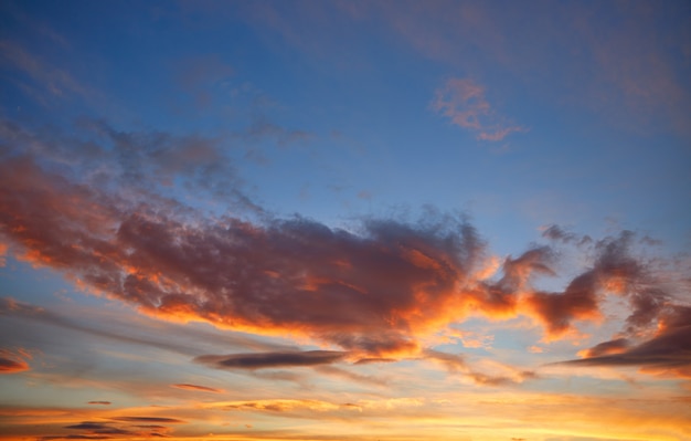 Céu do sol laranja nuvens sobre azul