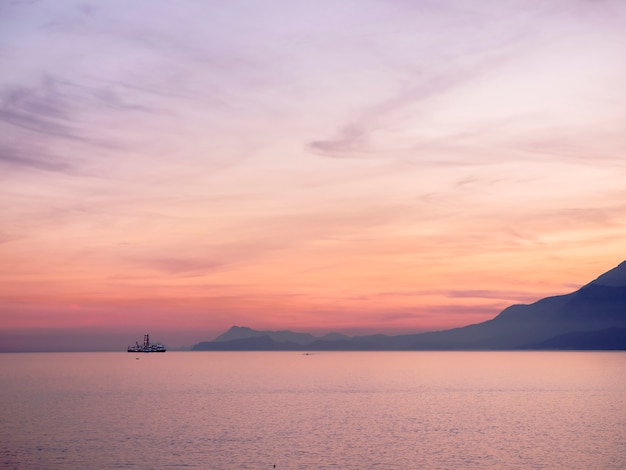 Céu do sol roxo sobre o mar azul