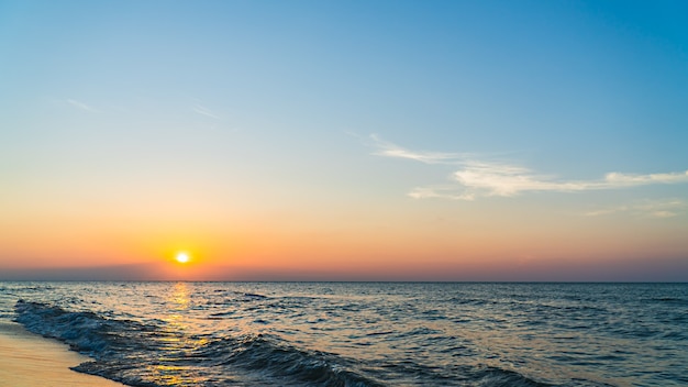 Céu do sol sobre o mar ao anoitecer