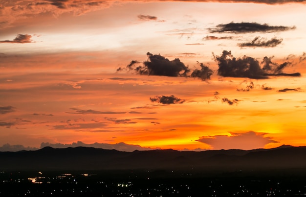 Céu dramático colorido com a nuvem no por do sol.