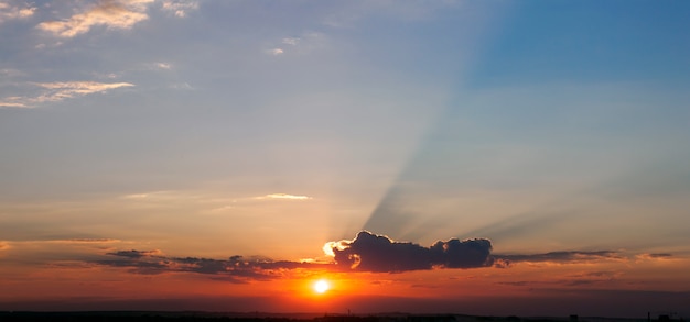 Céu dramático do sol com feixes de luz através do panorama de nuvens