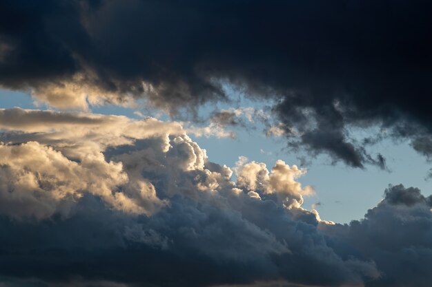 Céu dramático no crepúsculo do sol com nuvens pesadas. Oposição de luz e escuridão.