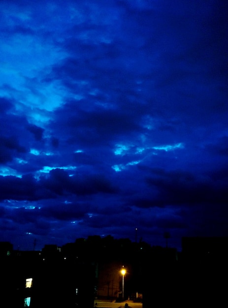 Foto céu dramático sobre a cidade iluminada ao anoitecer