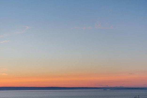 Céu durante o pôr do sol nas cores laranja e azul sobre o mar