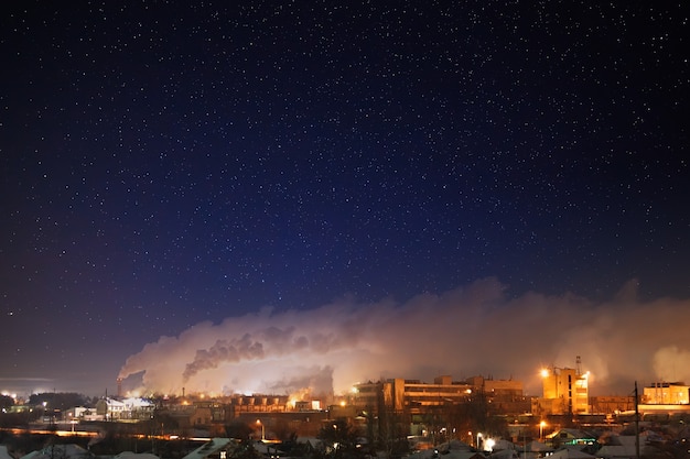 Céu estrelado à noite sobre uma área industrial da cidade