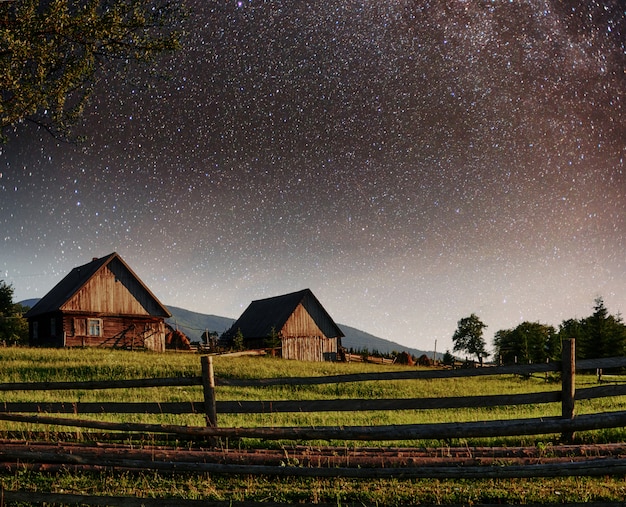 Céu estrelado fantástico pilhas e aldeias de montanha tradicionais. cárpatos, ucrânia