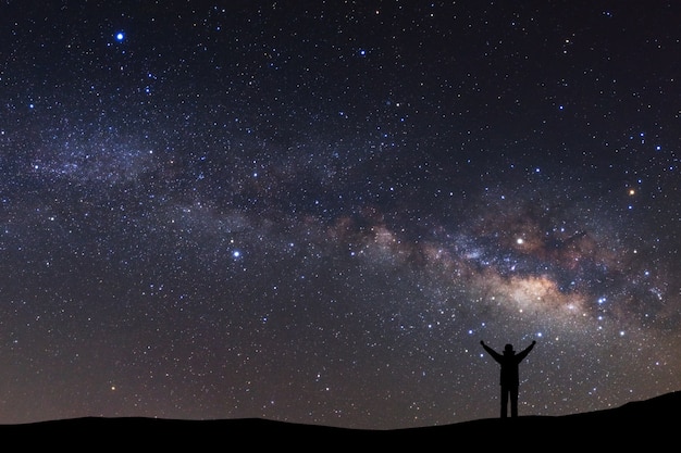 Céu noite, com, estrelas, e, silueta, de, um, ficar, desportivo, homem, com, levantado cima, braços