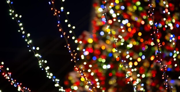 Foto céu noturno da árvore de natal e guirlandas. fundo de natal.