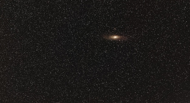 Céu noturno, muitas estrelas, galáxia de Andrômeda visível. Foto empilhada de longa exposição