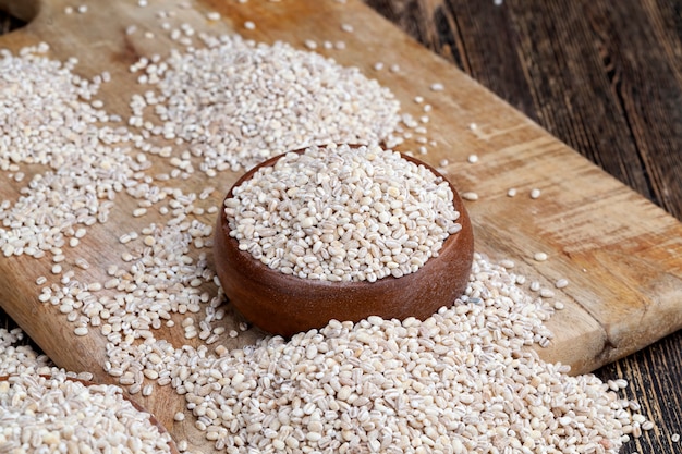 Cevada pérola para cozinhar mingau, cereais são espalhados em pratos sobre a mesa, cevada pérola é feita de cevada