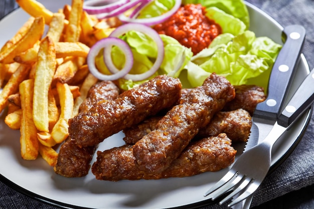 Cevapcici com batata frita alface cebola ajvar