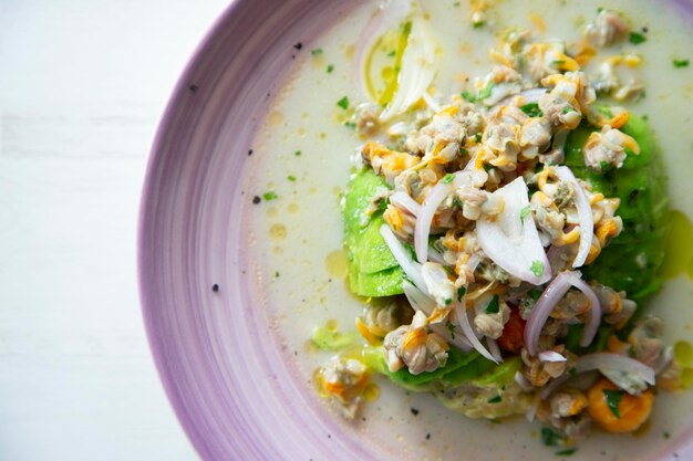 Ceviche de berbigão com milho torrado e abacate.