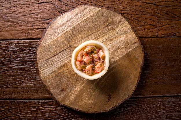 Ceviche de salmão com molho de maracujá em fundo de madeira