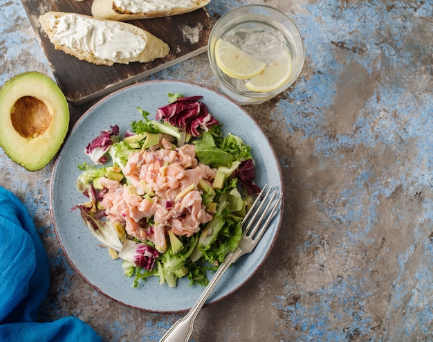 El ceviche es un plato tradicional del Perú. Salmón marinado en limón con lechuga fresca, aguacate y cebolla.