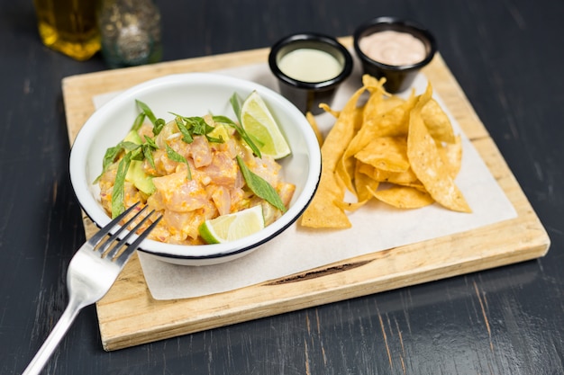 Ceviche con salsas y papas fritas en una mesa de madera