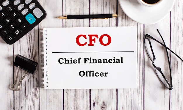 Cfo chief financial officer é escrito em um bloco de notas branco perto de uma calculadora, café, óculos e uma caneta