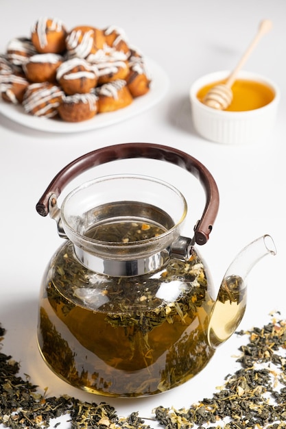 Chá chinês verde com raspas de laranja em um bule de vidro sobre um fundo branco