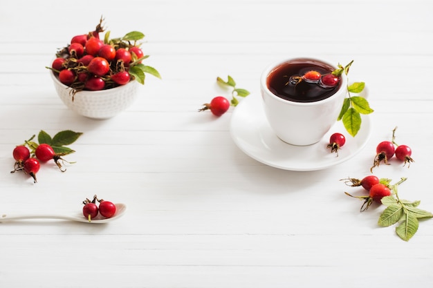 Chá com bagas de uma rosa brava em uma mesa de madeira