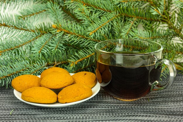 Chá com biscoitos no fundo de ramos de pinheiro.