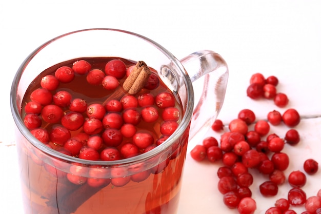 Chá com cranberry e canela em um Natal de madeira branco