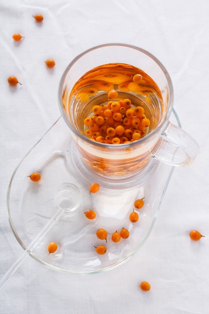 Chá com hippophae e mel, em um copo de vidro.