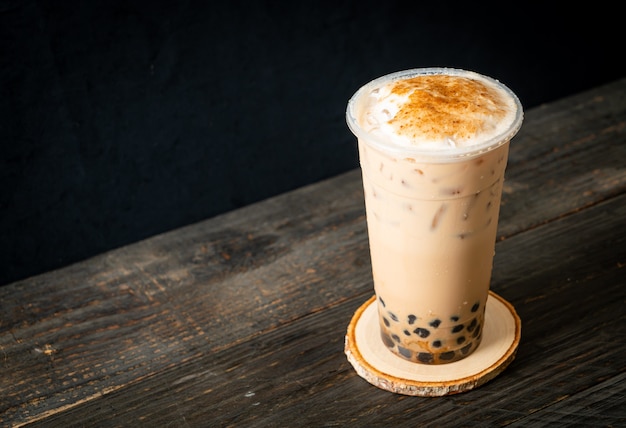 Chá com leite de Taiwan com bolha e queijo queimado na mesa de madeira