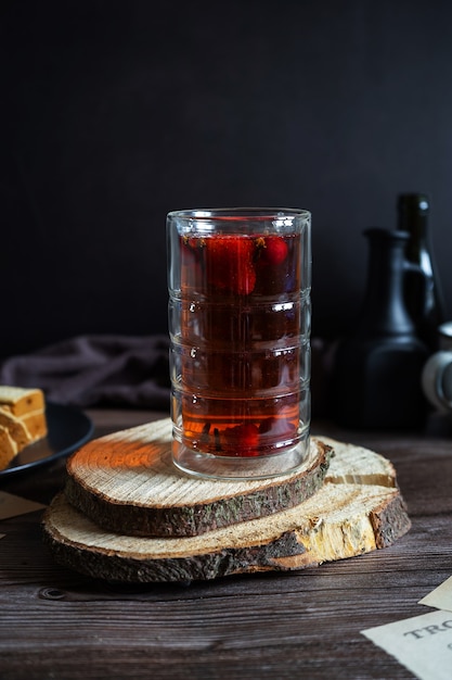 Chá com morangos e cerejas, bebida quente ou fria com frutas vermelhas. Fotografia discreta.