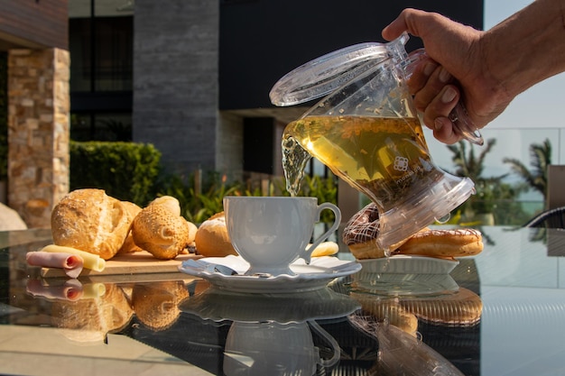 Chá da tarde servido em mesa decorada, café da tarde, croissant, pão de queijo, diversos alimentos