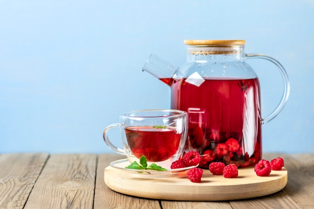 Foto chá de ervas com frutas, framboesas, folhas de hortelã e flores de hibisco