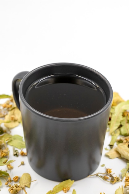 Foto chá de ervas de inverno isolado em um fundo branco chá de tília chá de ervas de reforço imunológico chá medicinal preparado a partir de folhas de tília partículas de cravo e camomila