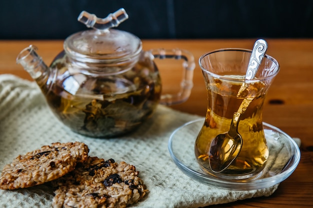 Chá de ervas em um copo de vidro com biscoitos de cereais
