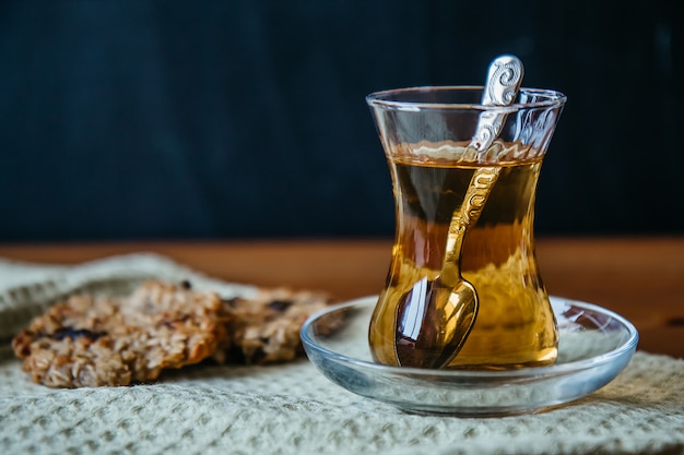 Chá de ervas em um copo de vidro com biscoitos de cereais