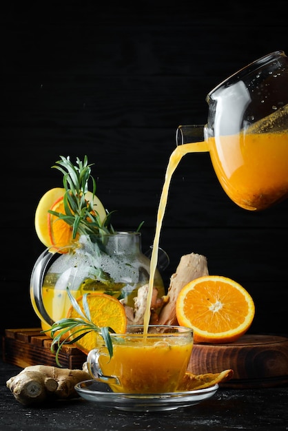 Chá de espinheiro marítimo com laranja e gengibre Bebidas quentes de inverno Em um fundo preto Vista superior