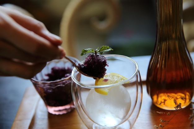 Chá de frutas vermelhas com bola de gelo no fundo de madeira