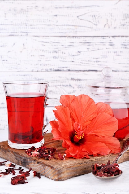 Chá de hibisco e flor a bordo em fundo de madeira