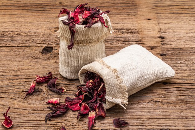 Chá de hibisco quente. pétalas secas, sacos de linho. comida saudável e conceito de autocuidado.