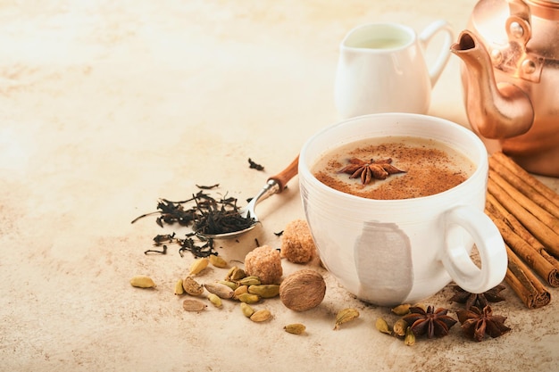 Chá de masala Chá de masala chai temperado com leite e especiarias em fundo bege quente claro Bebida tradicional indiana Espaço de cópia Foco seletivo