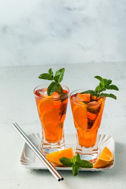 Chá de menta de verão com laranja em um copo alto refrescante refrigerante