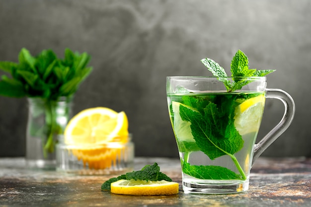 Chá de menta em um copo de vidro em uma mesa de concreto