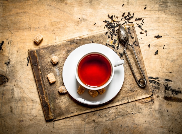 Chá de sabor forte com açúcar de cana na mesa de madeira.