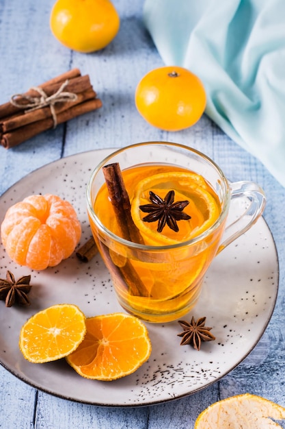 Chá de tangerina fresco com canela em um copo sobre a mesa Bebida de vitaminas Visão vertical