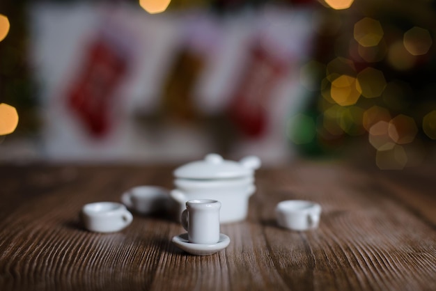 Chá em miniatura sobre fundo de mesa de madeira com decorações de Natal