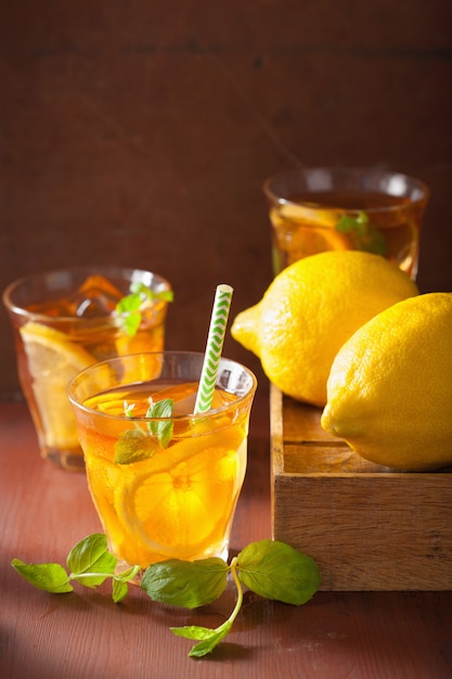 Chá gelado com limão e hortelã na mesa rústica escura