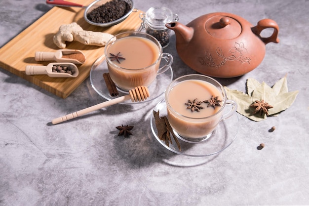 Chá indiano masala. Chá com leite e especiarias em colheres de madeira. Orientação horizontal