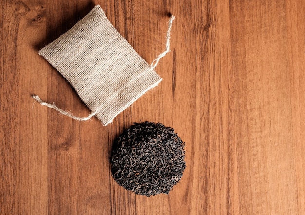 Chá indiano preto seco com saco de estopa vintage em fundo de madeira